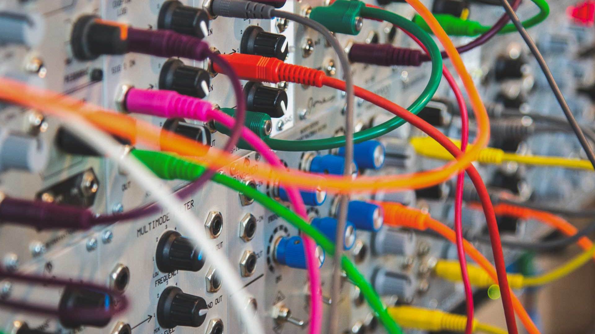 Photo by John Carlisle on Unsplash of the colorful wires used to configure an analog synth