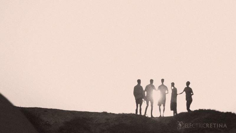 a simple image of five figures silhouetted by the sunset